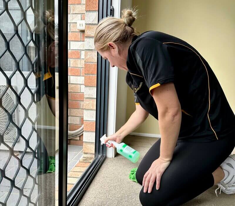 Professional cleaner, Jarna spraying the sliding door track