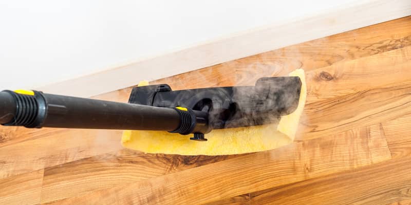 Wooden, parquet, laminate floors cleaning with steam in the room