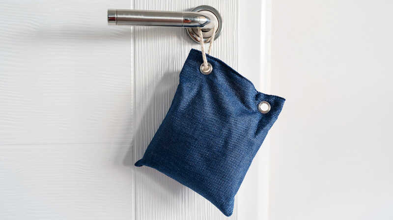 Close up on air purify bag charcoal activated carbon moisture absorber and odor eliminator hanging on the door.