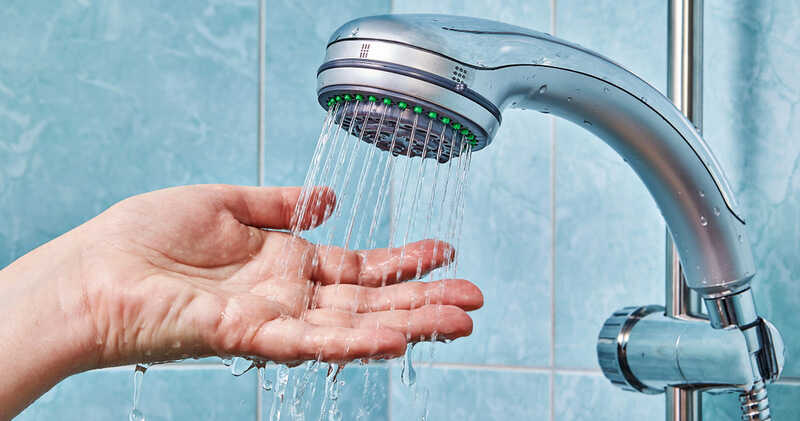 Hand checks the water that flows from the shower