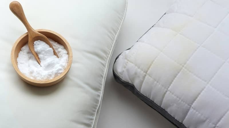 yellowed pillow and baking soda (sodium bicarbonate) on white background. Home cleaning concept.