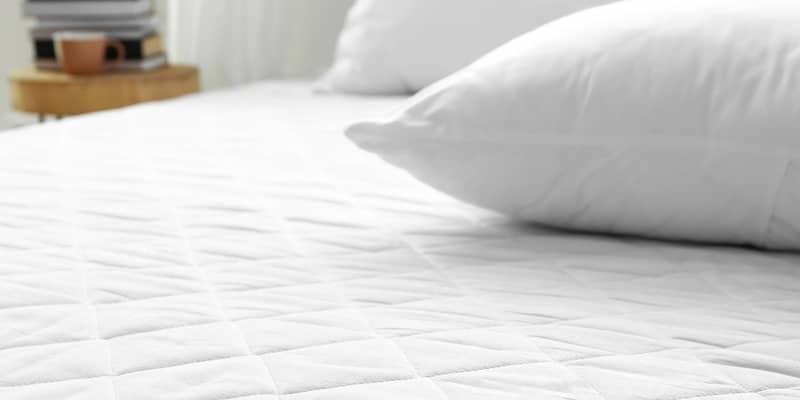 Soft mattress on bed in room, closeup