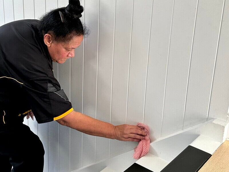 professional cleaner wiping the walls and skirting boards in the stairs