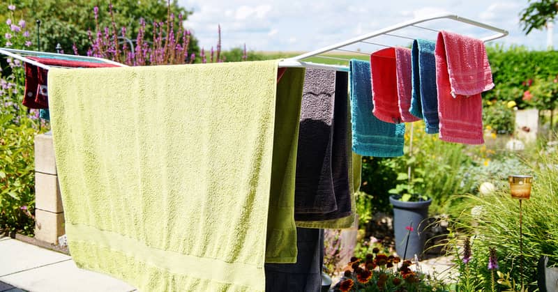 Rack dryer standing on the terrace on sunny day for drying multicolored towels