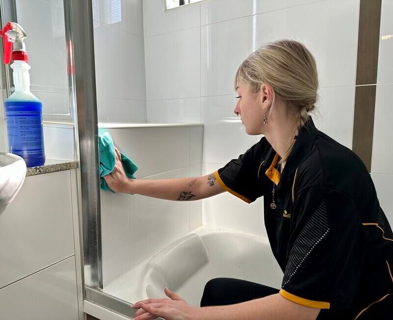 Casey cleaning bathroom