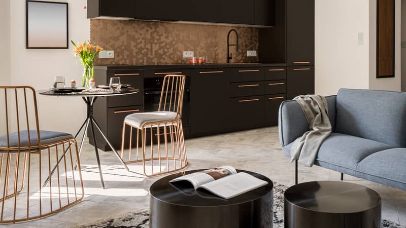 Small and trendy designed flat interior with stylish black and gold kitchen, new style dining area and elegant living room