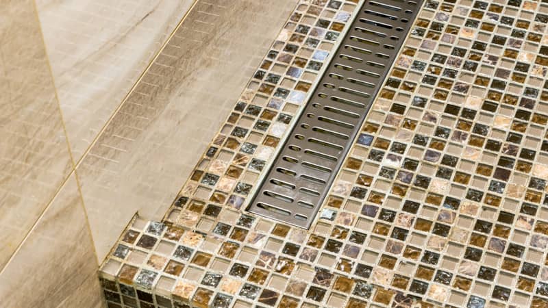 shower room floor with glass tiles and metal drain