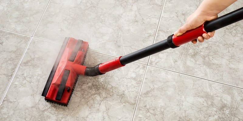 woman cleaning floor steam cleaning into the room