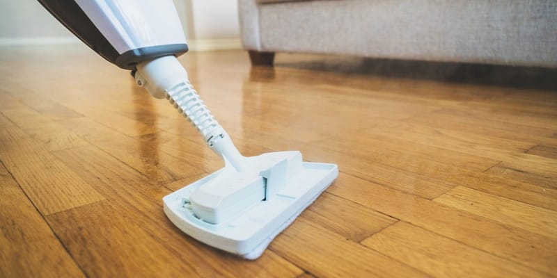 Cleaning the floor with a dry steam cleaner.