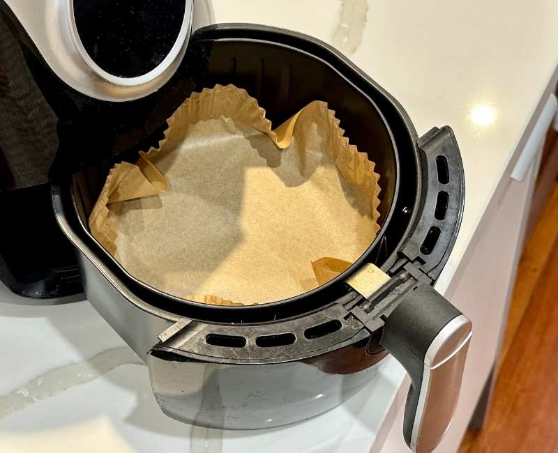 Air fryer with parchment lining in the basket