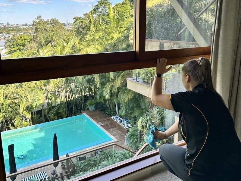 professional cleaner wiping windows with microfibre cloth