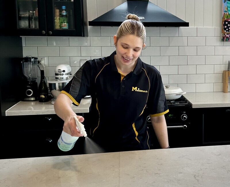 Kate-lyn spraying cleaning solution on a Caesarstone benchtop