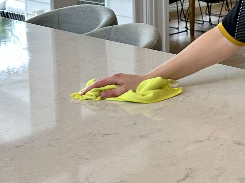 professional cleaner cleaning a stone benchtop using microfibre cloth