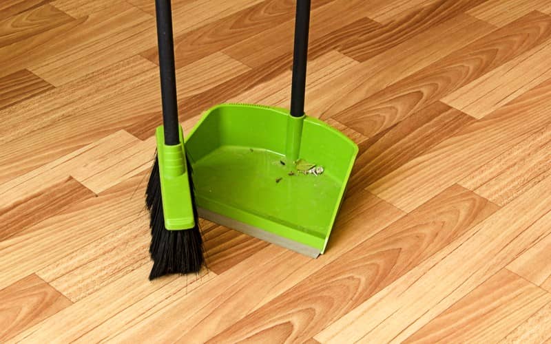 sweeping the laminate floor with broom
