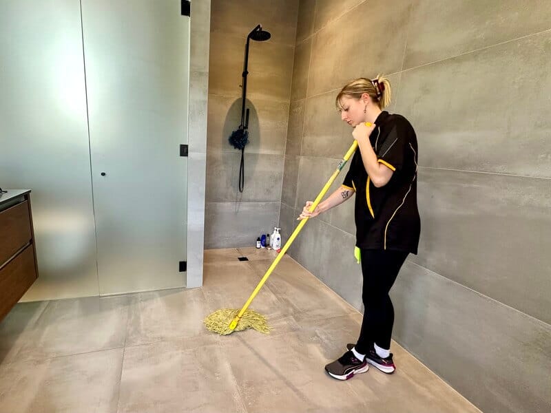 professional cleaner using string mop to clean the floor with tiles