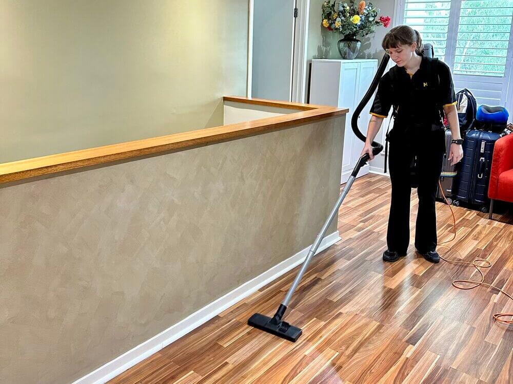 Kayleigh vacuuming a hybrid floor