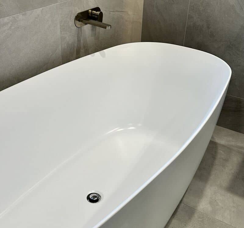 freshly cleaned bathtub inside a tiled bathroom