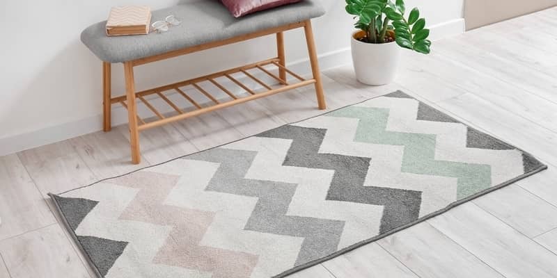 Soft carpet and comfortable bench on light wooden floor in room interior