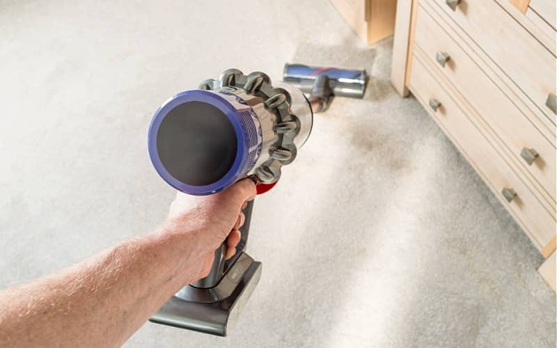 cleaning a bedroom carpet with a vacuum cleaner