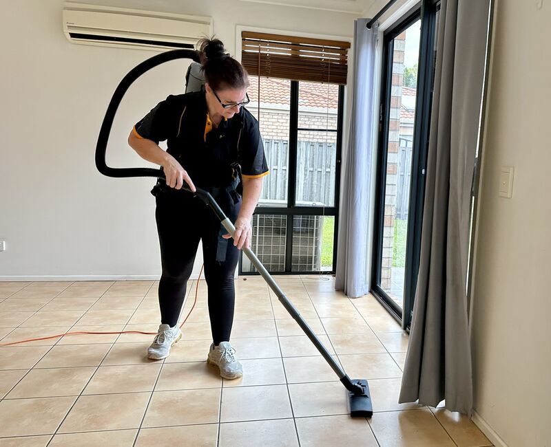 Renee vacuuming tiled floor