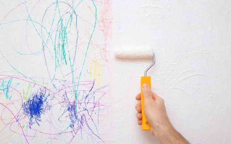 hand holding a roller painting over the permanent marker