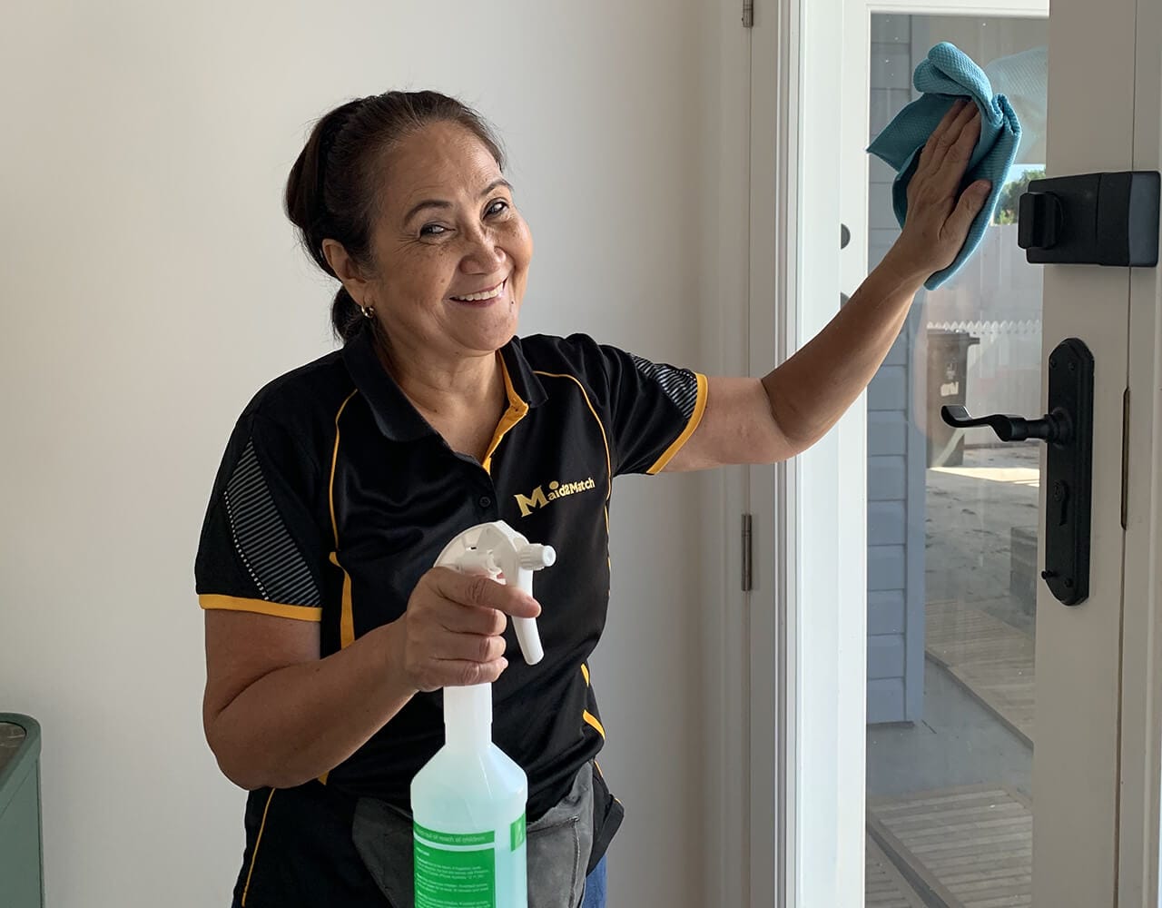 Lorena smiling cleaning front door img