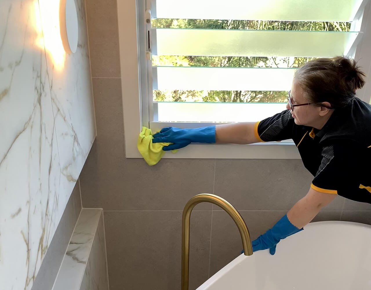 Mihaela attention to detail Maid2Match professional Mihaela wiping the corners of a bathroom window