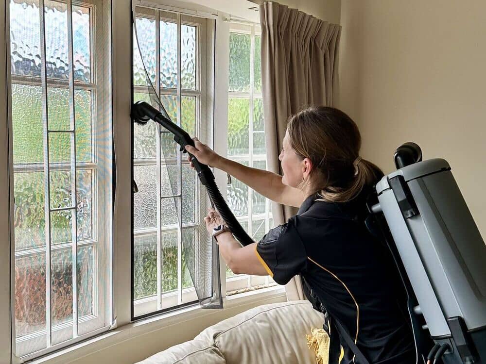 professional-house-cleaner-Lia-vacuuming-the-window-with-fly-screen Brisbane professional house cleaner Lia vacuuming the window with fly screen using vacuum