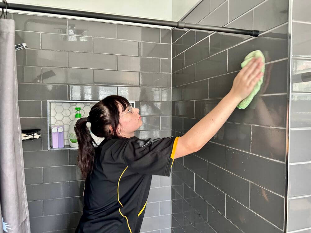 Tullie cleaning the shower tiles