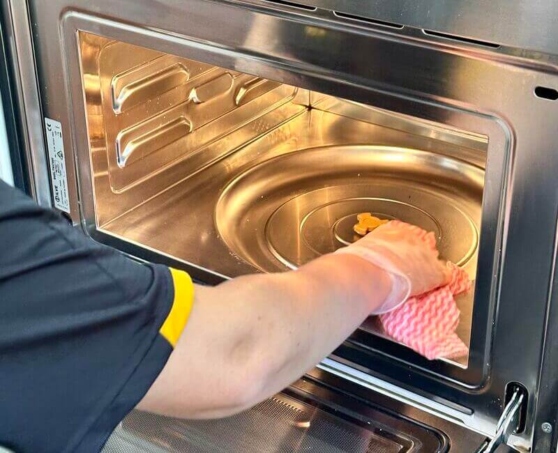 cleaner cleaning inside the microwave