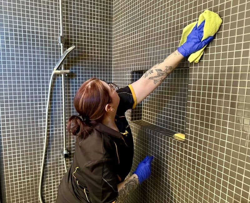 Geelong professional house cleaner Paris wiping shower tiles with microfibre cloth