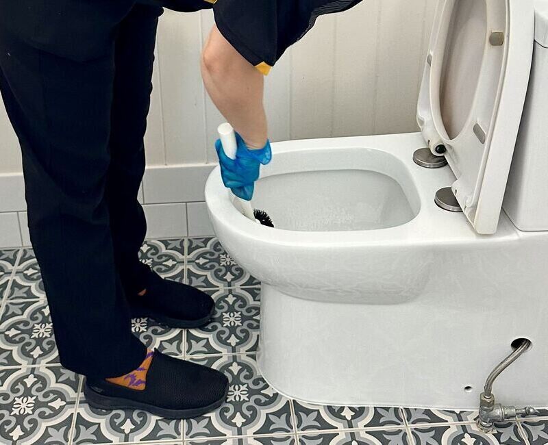 Maid2Match Brisbane house cleaner brushing the inside of a toilet