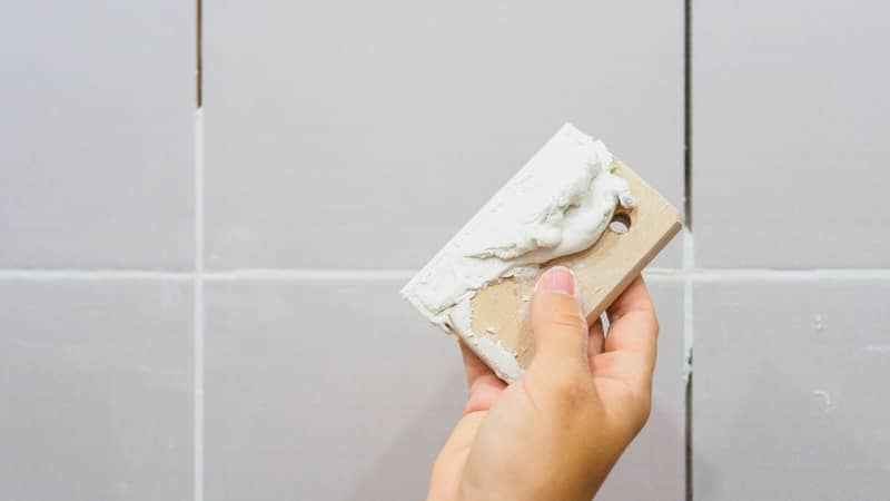 Grouting between tiles in the bathroom.