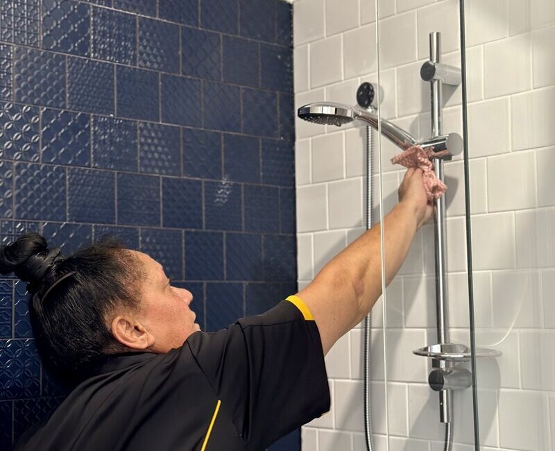 professional cleaner Janet cleaning shower arm