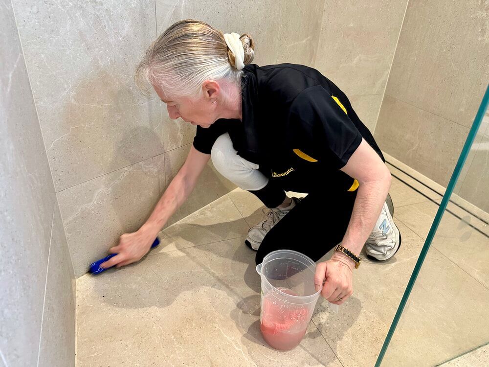 Gold-Coast-professional-cleaner-Lisa-scrubbing-shower-floor-tiles Maid2Match cleaner Lisa B scrubbing the tiles on the shower floor