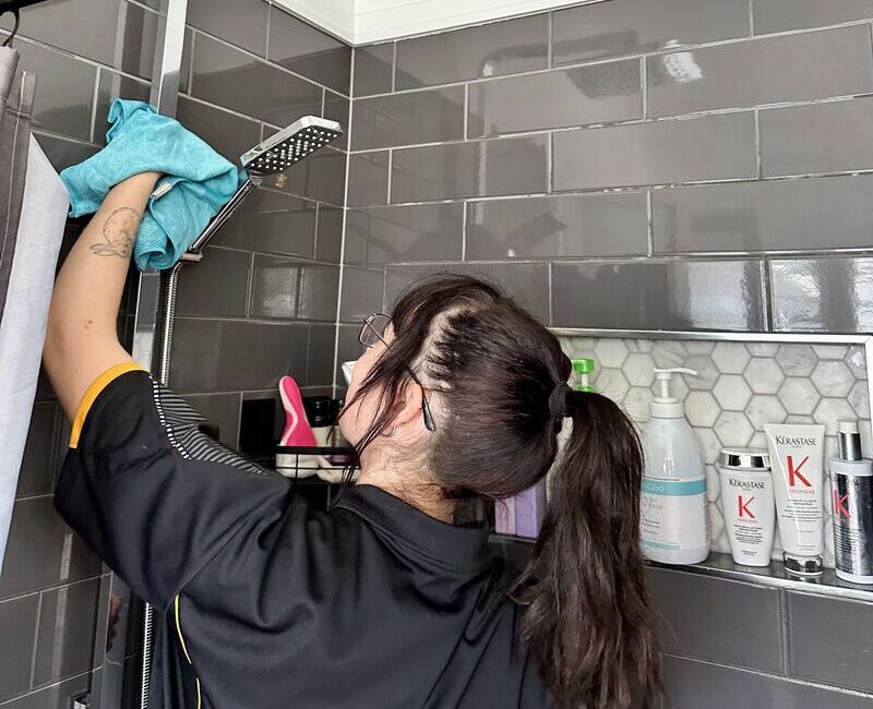 professional cleaner Tullie cleaning around the shower head
