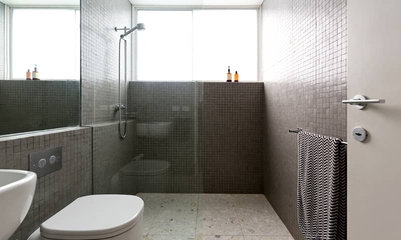 Modern walk in shower with mosaic full height tiles and terrazzo floor