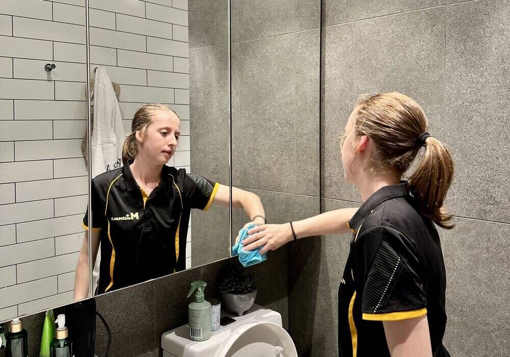 Jade-cleaning-bathroom-mirror Maid2Match professional house cleaner Jade cleaning bathroom mirror