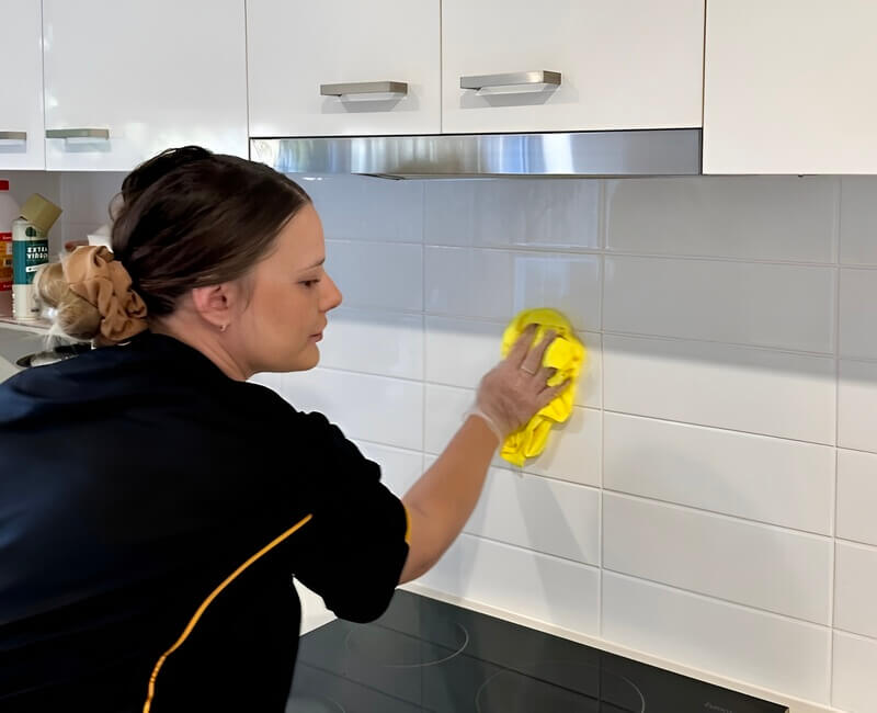 Maid2Match expert house cleaner Alison cleaning the grout lines of kitchen splashback