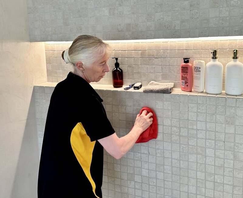 Maid2Match cleaner Lisa B cleaning tile grout of the shower wall