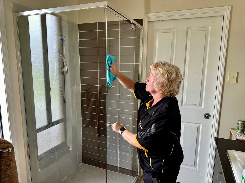 Professional-house-cleaner-Nicola-cleaning-shower-glass Gold Coast Field Staff Trainer and professional house cleaner Nicola cleaning shower glass