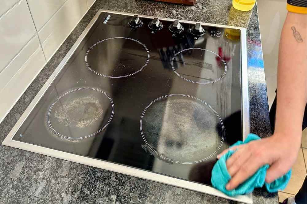 professional cleaner wiping an electric stove top