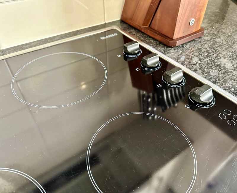 Close-up of a clean electric stove top with knobs on the right side