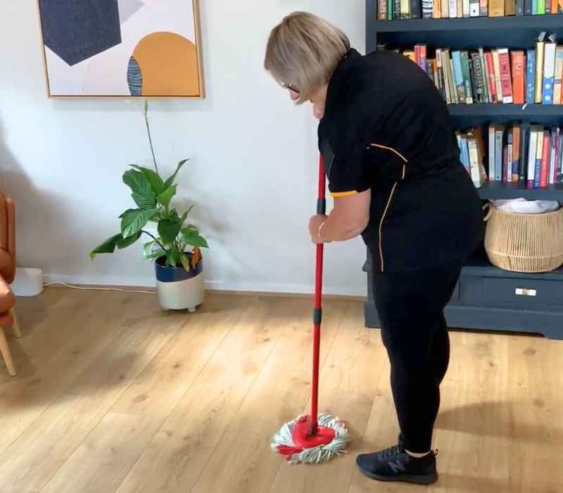 professional cleaner using spin mop on hardwood floor