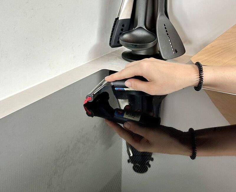 Cleaner scraping off stains from glass cooktop