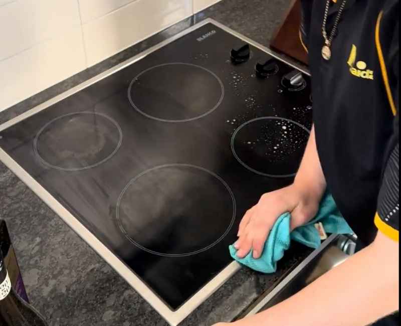 professional cleaner wiping electric stove top