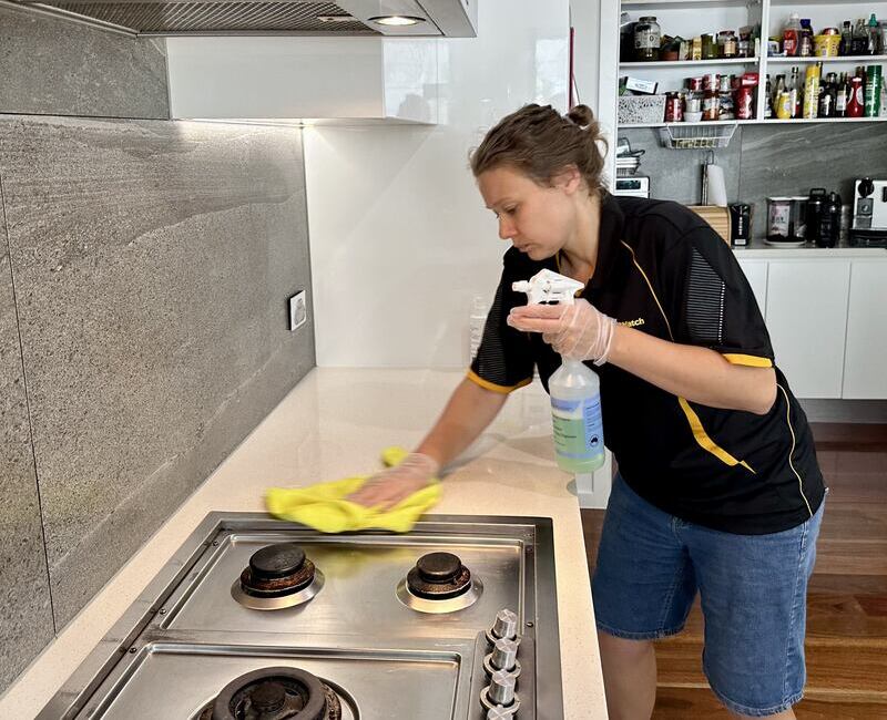 Maid2Match house cleaner Acama wiping stainless steel cooktop