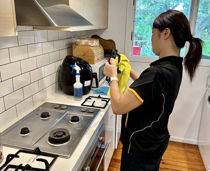 Maid2Match professional house cleaner Shinobu cleaning stovetop grates with microfibre cloth