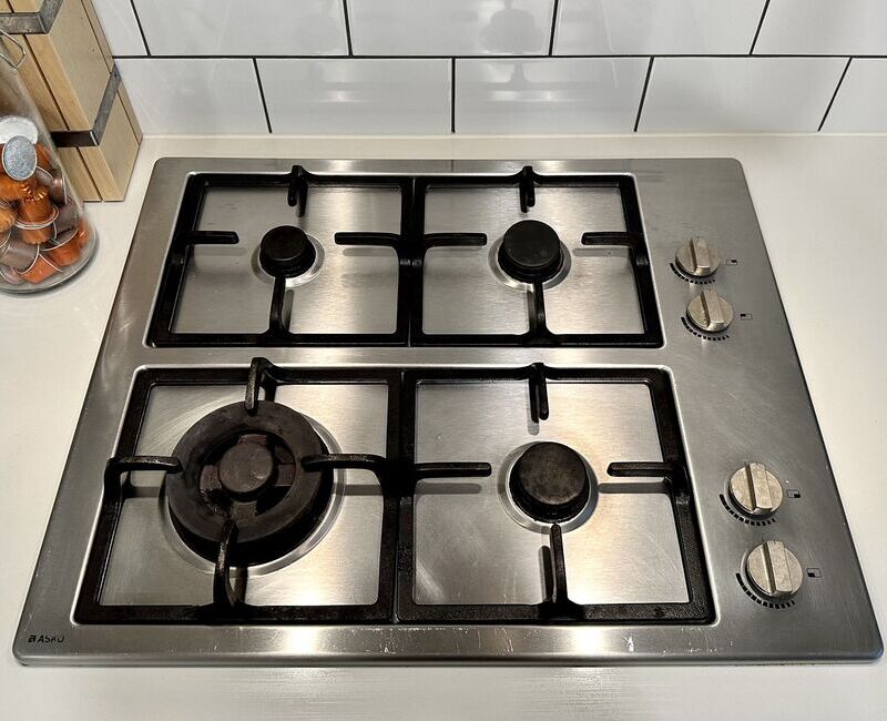 Close up view of a clean stainless steel cooktop with the grates