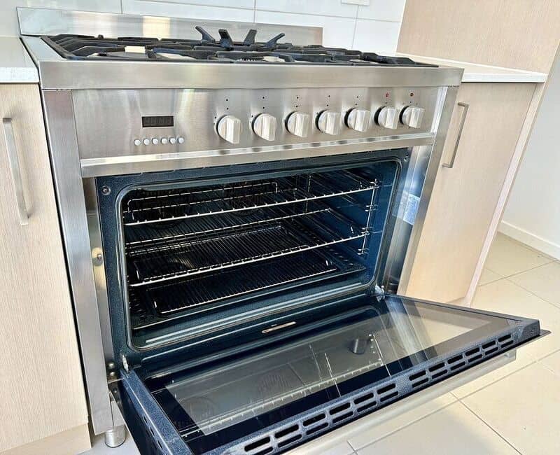 Open oven with clean oven racks and tray inside